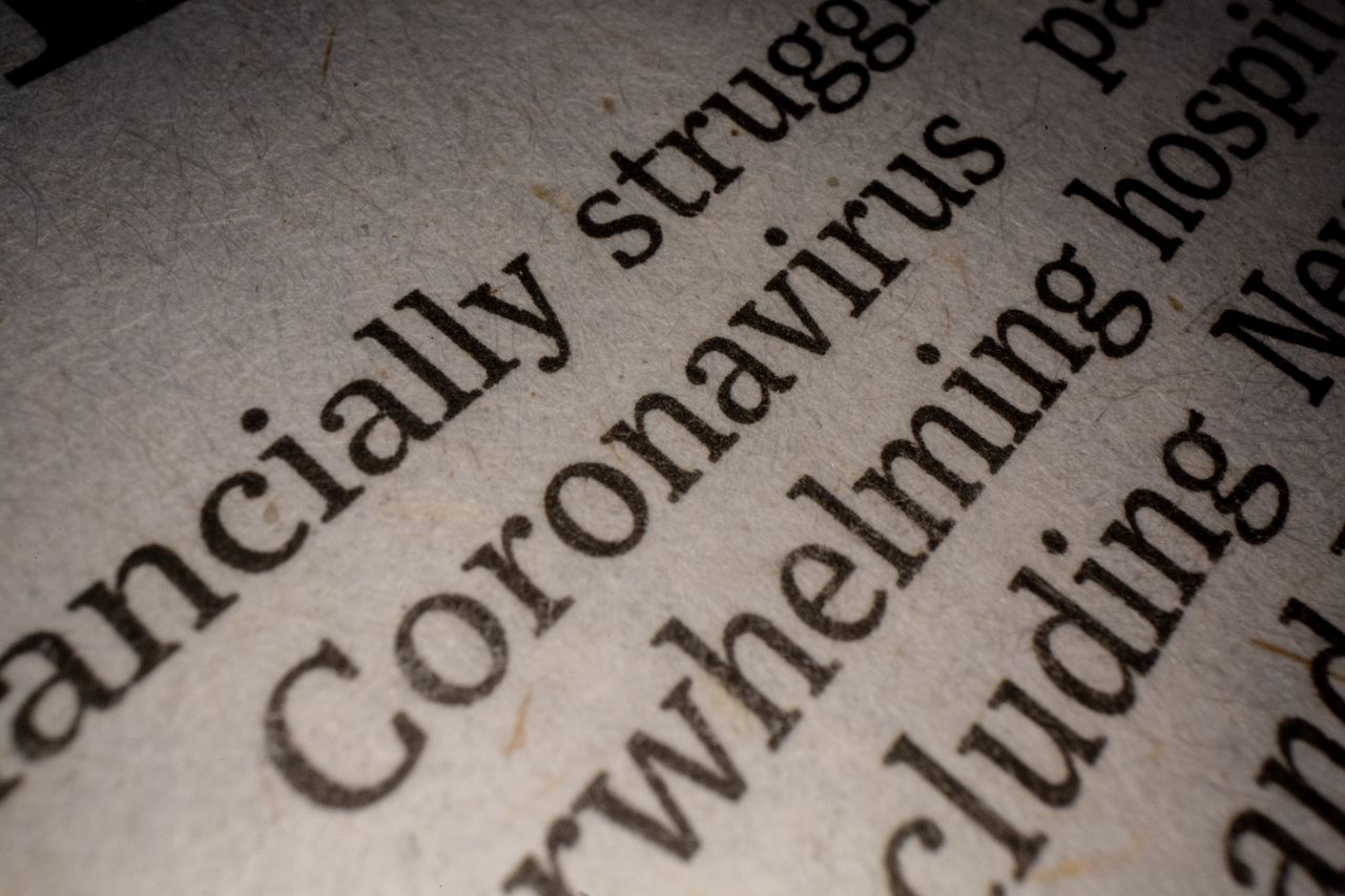 Close-up of a white article page with black text about coronavirus pandemic research and its impact on the economy